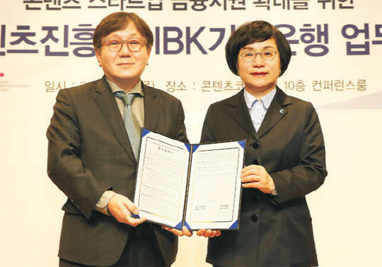 권선주 IBK기업은행장(오른쪽)과 송성각 한국콘텐 츠진흥원장이 지난 2월 문화콘텐츠 강소기업 육성 을 위한 협약식을 마치고 기념촬영을 하고 있다. 사진=IBK기업은행 제공